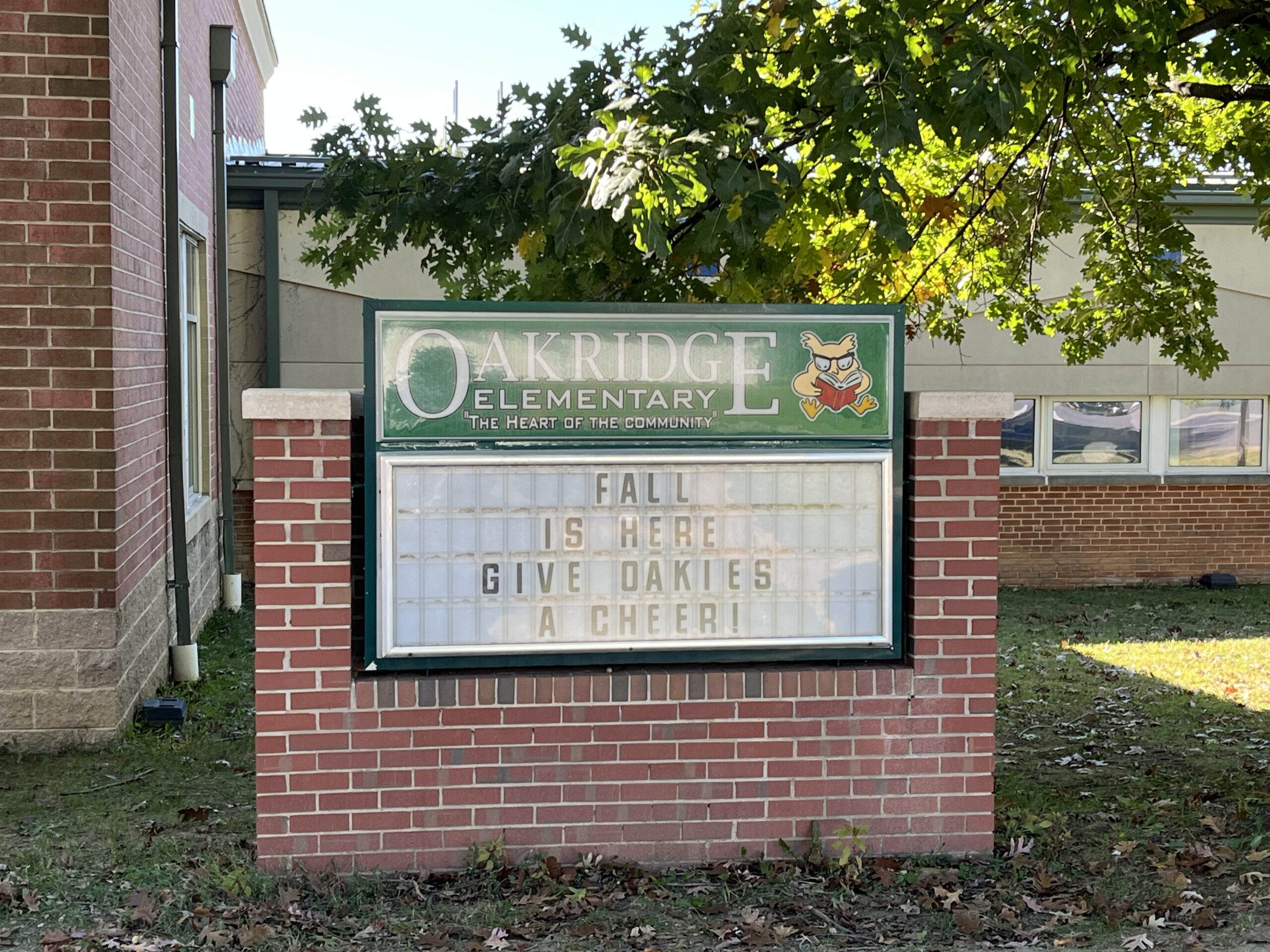 Oakridge Elementary School's front message board with the sun and tree in background. Message board reads Fall is here Give Oakies a Cheer!